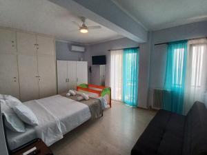 1 dormitorio con cama, sofá y ventanas en Als Plomari - Sea View Apartment, en Plomari