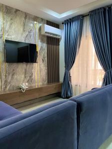 a living room with a blue couch and a tv at 1oakapartments in Abuja