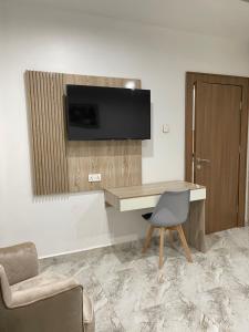 Cette chambre dispose d'un bureau, d'une télévision et d'une chaise. dans l'établissement 1oakapartments, à Abuja