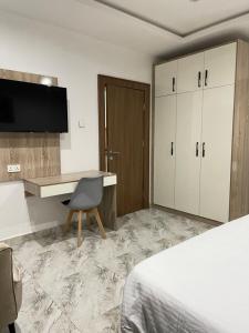 a hotel room with a desk and a bed at 1oakapartments in Abuja