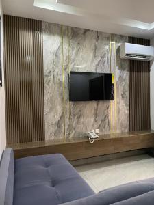 a living room with a tv on a stone wall at 1oakapartments in Abuja