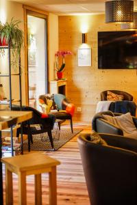 a living room with couches and chairs and a television at Hotel Le Faranchin in Villar-dʼArène