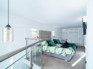 ein Schlafzimmer mit einem Bett mit grünen Kissen in der Unterkunft Stylish Spacious 1 Bedroom Apt At Dealhouse in Huddersfield