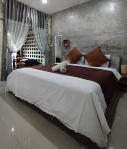 1 dormitorio grande con 1 cama grande con sábanas blancas en บ้านพักบุหงา199 อ สรรพยา en Sanphaya