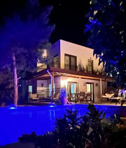 una villa con piscina di notte di Mavilimon a Sarıbelen