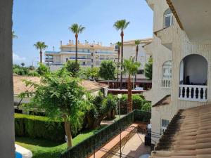 uitzicht vanaf het balkon van een gebouw met palmbomen bij Nice and cozy flat with pool next to the beach in Albir