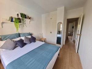 een slaapkamer met een groot bed met blauwe kussens bij Nice and cozy flat with pool next to the beach in Albir