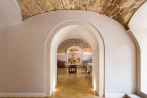 Une arche mène à une salle à manger et à un salon. dans l'établissement Palazzo Artemide - VRetreats, à Syracuse