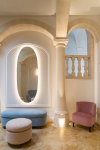 Palazzo Artemide - VRetreats في سيراكوزا: غرفة معيشة مع أريكة زرقاء وكرسي