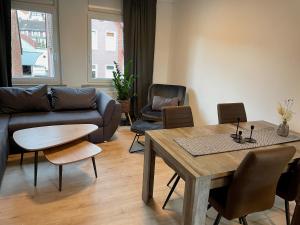 a living room with a couch and a table and chairs at FLATLIGHT - Stylish apartment - Kitchen - Parking - Netflix in Hildesheim