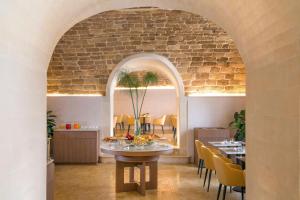 una sala da pranzo con tavolo e sedie gialle di Palazzo Artemide - VRetreats a Siracusa