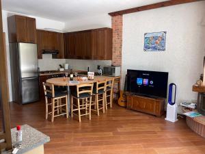 een keuken met een tafel met stoelen en een televisie bij Lario House in Limonta