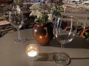 tres copas de vino sentadas en una mesa con una vela en Hvězdný glamping, en Manětín