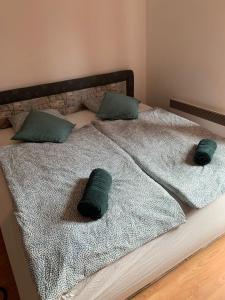 Una cama con dos almohadas verdes. en Prostorný rustikální apartmán v Beskydech, en Kunčice pod Ondřejníkem