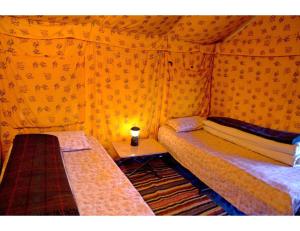 a small room with two beds and a table at Dorje Camps Sarchu, Manali in Manāli