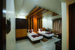 un soggiorno con due letti e un divano di Urban Suites a Bhubaneshwar