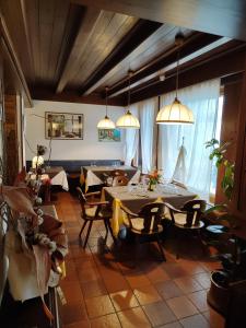 una sala da pranzo con tavoli, sedie e luci a ciondolo di Al Sole Hotel Ristorante dal 1870 a Pieve di Cadore