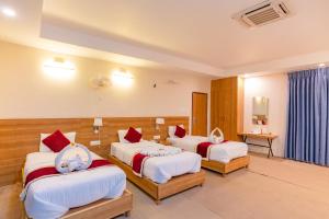 una camera d'albergo con tre posti letto di Siddhartha Resort, Chisapani a Chisāpānī