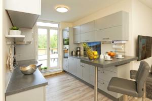a kitchen with white cabinets and a table with fruit on it at Kapitaensweg 2 Kajuete 07 in Ostseebad Karlshagen