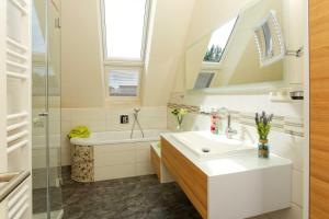 a bathroom with a sink and a tub and a mirror at Kapitaensweg 2 Kajuete 07 in Ostseebad Karlshagen +17 photos