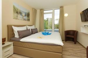 a bedroom with a bed with a blue bow on it at Kapitaensweg 2 Kajuete 07 in Ostseebad Karlshagen