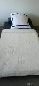 Una cama blanca con una almohada encima. en BELLEVUE, en Quetigny