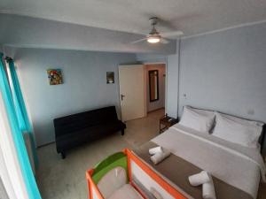 1 dormitorio pequeño con 1 cama y 1 sofá en Als Plomari - Sea View Apartment, en Plomari