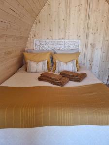 a bed in a wooden room with two blankets on it at Villa Das Alfarrobas Eco Design Cabin in Algoz