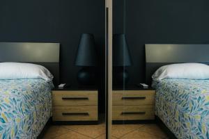 a bedroom with two beds and a mirror at Castelvecchio City Center Apartment in Verona
