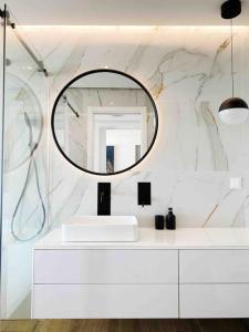 a bathroom with a white sink and a mirror at Front Sea Apartment Albufeira in Albufeira