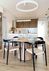 a dining room with a table with wine glasses on it at Front Sea Apartment Albufeira in Albufeira