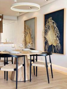 a dining room with two tables and chairs and paintings at Front Sea Apartment Albufeira in Albufeira +13 photos