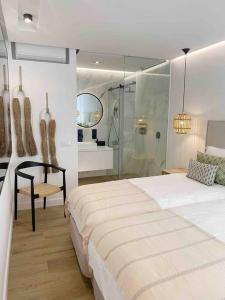 a bedroom with a bed and a glass shower at Front Sea Apartment Albufeira in Albufeira