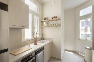 a white kitchen with a sink and a window at Loft in Acropolis in Athens