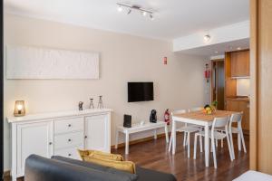 a living room with a kitchen and a dining room table at Apartamento na Praça by An Island Apart in Funchal +41 photos