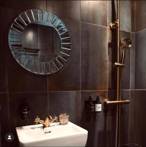 bagno con lavandino e specchio di The Falcon Hotel ad Allinge