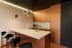 eine Küche mit einer weißen Theke und einigen Stühlen in der Unterkunft Salt Island Apartments in Kołobrzeg