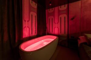 eine Badewanne im Bad mit roter Beleuchtung in der Unterkunft Salt Island Apartments in Kołobrzeg