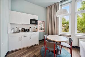 a kitchen and dining room with a table and chairs at limehome Berlin Stresemannstr in Berlin
