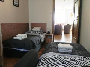 a room with two beds and a chair in it at Apartament Nadstawna klimatyzowany in Biłgoraj