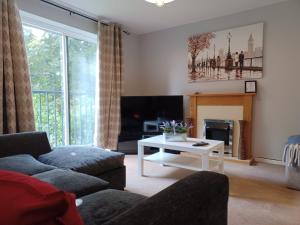 a living room with a couch and a table at Huku Kwetu -The Maltings White Door-1st Floor-2 Bedroom Apartment -Self Catering-Quiet- Free Parking in Dunstable