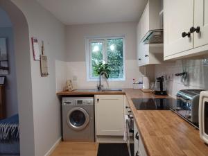 a kitchen with a washing machine and a sink at Huku Kwetu -The Maltings White Door-1st Floor-2 Bedroom Apartment -Self Catering-Quiet- Free Parking in Dunstable