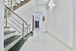 a corridor of a white building with stairs at OYO Flagship Rainbow Homestay in Gulzārbāgh