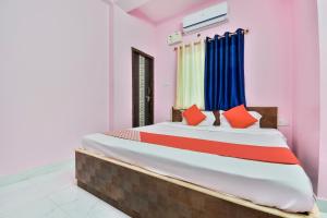 a bedroom with a large bed with red and blue pillows at OYO Flagship Rainbow Homestay in Gulzārbāgh