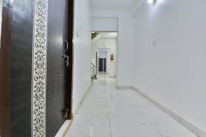 an empty hallway with a door and a tile floor at OYO Flagship Rainbow Homestay in Gulzārbāgh