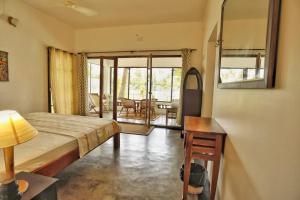 a bedroom with a bed and a table and a room at Vala House in Cherai Beach