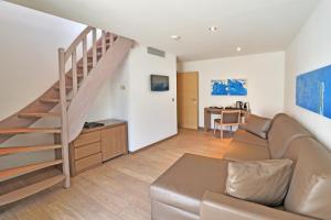 a living room with a couch and a staircase at Hôtel Le Rocher in Calvi