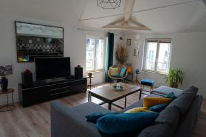 a living room with a couch and a tv at La Quintessence - Amboise Hypercentre in Amboise