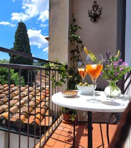 einen Balkon mit einem Tisch und Gläsern Wein in der Unterkunft Apartment San Frediano in Florenz