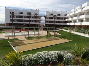 オリフエラ・コスタにあるTerrazas de Campoamor 3056の中庭にテニスコートがあるアパートメントビル